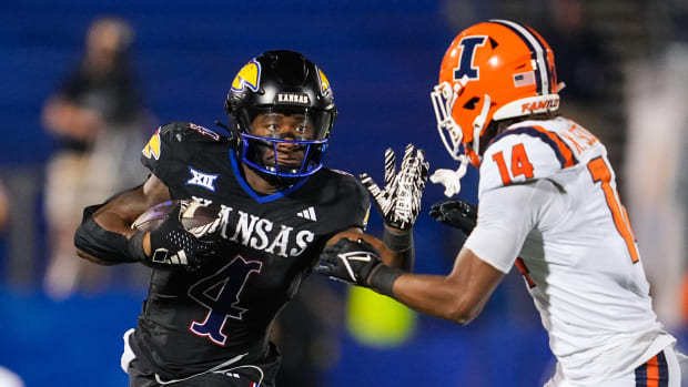 Sep 8, 2023; Lawrence, Kansas, USA; Kansas Jayhawks running back Devin Neal (4) runs the ball against Illinois Fighting Illini defensive back Xavier Scott (14) during the second half at David Booth Kansas Memorial Stadium. Mandatory Credit: Jay Biggerstaff-USA TODAY Sports  
